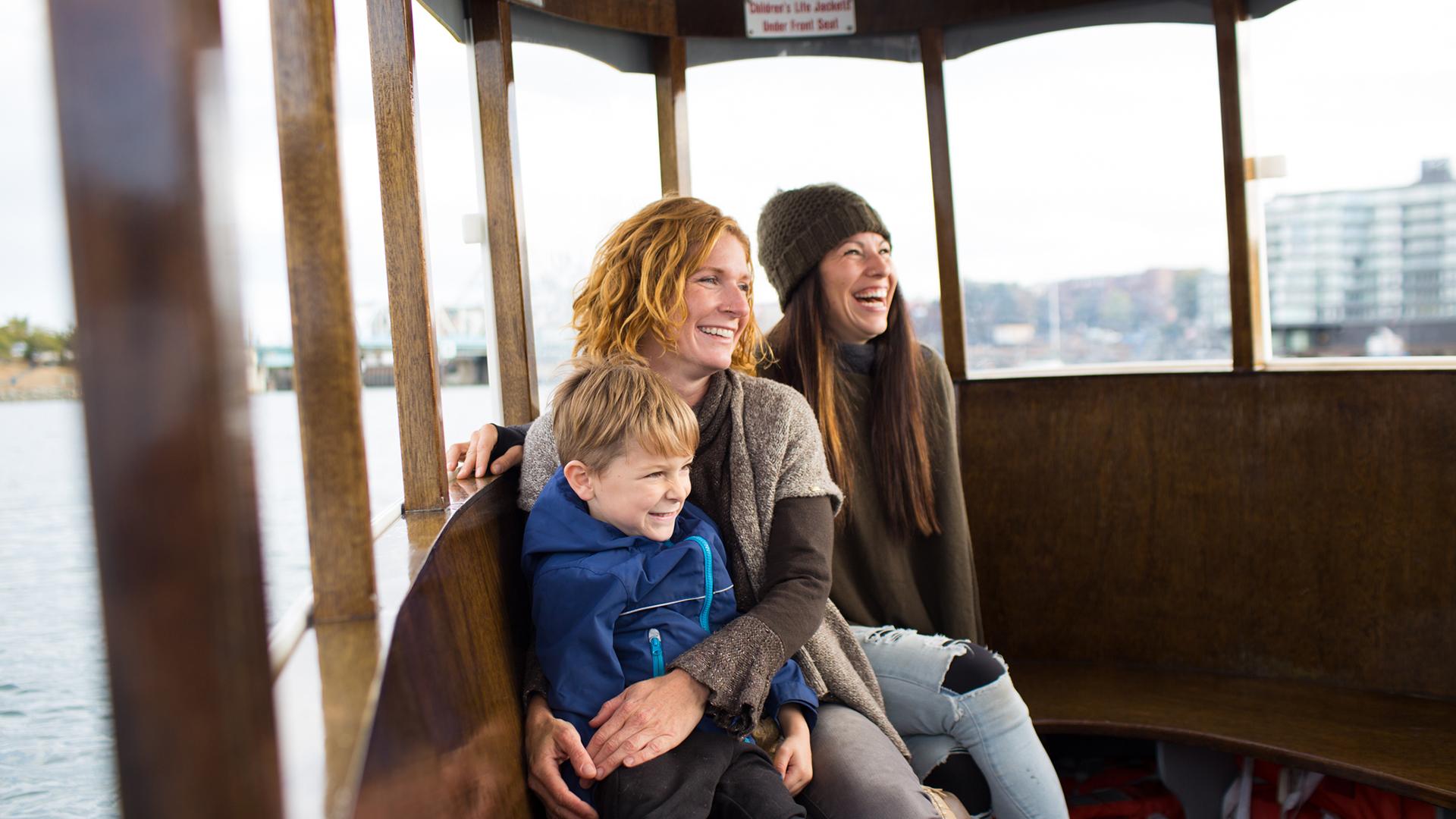 a happy family aboard a ferry in Victoria's inner harbour