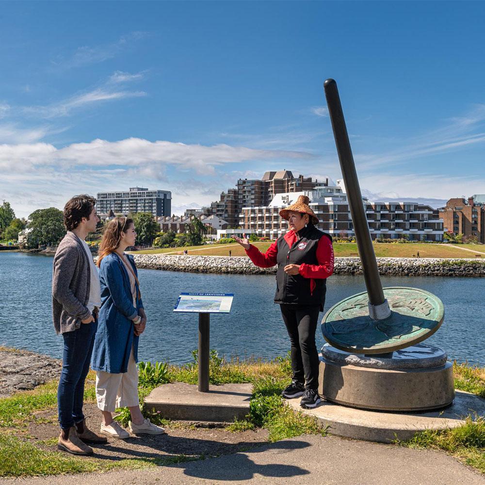 A couple learns about local Indigenous culture at one of the Seven Signs of the Lekwungen in Victoria, BC.