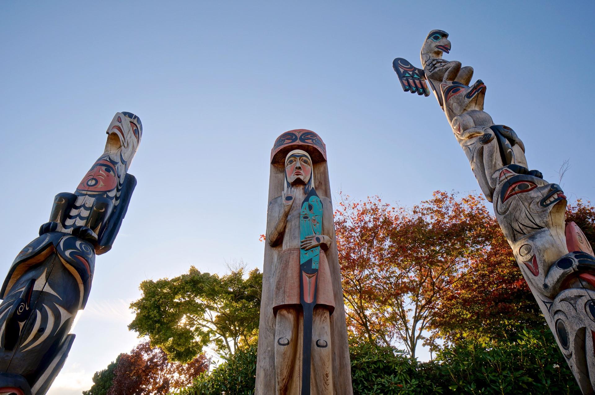 Orca & Thunderbird
This totem depicts one of the most important historical legends in Coast Salish history. The Thunderbird seen on the tail of the orca is a spiritual being and can only be accessed through communication with the creator. It is usually a plea for help.
The orca is the most respected creature of the sea. It is held in very high respect by Coast Salish people because of its physical powers and superior intellect. They survive in packs like wolves and are sometimes designated in the same realm as wolves of the sea.
A coming together of thegreat spiritual power and awesome physical power can be seen as a balance of power beneficial to mankind as seen through First Nations beliefs.
Salish Welcome Figure
In the past, human figures were carved in much greter than life size. They stood in front of villages with hands and arm held in a welcome gesture.
This welcome figure is based on a traditional Coast Salish welcome figure that would have been seen in front of villages. They faced the water and welcomed arriving visitors. The hands and arms of this figure shows the welcome gesture as well as an arm holding a paddle, showing that the people of the First Nation from Saanich are people of the canoe and paddle. These are symbols of welcome and thanks as well as survival.
Raven, Wolf, and Bear
This totem is a depiction of a bird and animals held in high esteem bu the Saanich people. In the days of the past, when forests, oceans, rivers and streams were in pristine condition, animals, birds, sea creatures, and mankind of the Saanich First Nations held a close relationship to each other. They shared the space provided by our creator "XAIES"; along with a closer understanding and respect between mankind, our brothers and sisters, and other life forms which we believe we are a part of.
On this pole the Raven sits atop the head of the Wolf and below the Wolf is the Bear clutching a salmon. The Raven is Saanich mythology is noted for its intelligence and is regarded as a messenger as it flies its daily path across the sky, waters, forests, and villages spreading the news of the day. This intelligent bird loves to play tricks on all including mankind as it makes its daily journey. In many First Nations culturs the Raven is acknowledged for its ability to transform into other deities further enhancing its reputation as the trickster and messenger.
The second figure under the Raven is the Wolf. The Wolf at one time inhabited this ground and surrounding areas. Wolves were regarded as keepers of the night and could be heard talking to each other over great distances. They were regarded as protectors and guarded our sacred places such as the top of Mt. Newton - a place reserved for survival of such things as the great flood as well as our place for meditation, purification, and fasting and coldwater rituals. Wolf packs and Orca pods are revered by First Nations as one and the same.
The Bear on the bottom of this pole is holding a salmon to show that he or she is also a fisherman and survivor. Bears are respected and regarded as our equal as family caretakers and will rigourously defend their young as does man. Bears are respected as people and can be seen fishing in close proximity to our fisherman in the shallows of rivers as the salmon journey upstream. We have a saying which says, "salmon for survival are survival for salmon." Bears believe this as do we and we have a mutual respect for each in this regard.
Charles W. Elliott is an internationally recognized Master Carver and fine artist in the Coast Salish tradition. His art works are in private and corporate collections worldwide. Charles is a member of the T'sartlip First Nation and was born on the T'sartlip Reserve in Brentwood Bay, BC. He continues to live there today on the shores of the Saanich Inlet with his wife Myrna and their children.
As a young artist, Charles carved designs on the bark of the cottonwood tr