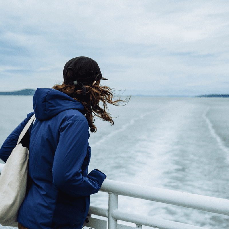 A Woman in a Blue Jacket Enjoys the Views on a B.C. Ferries Ride A Woman in a Blue Jacket Enjoys the Views on a B.C. Ferries Ride