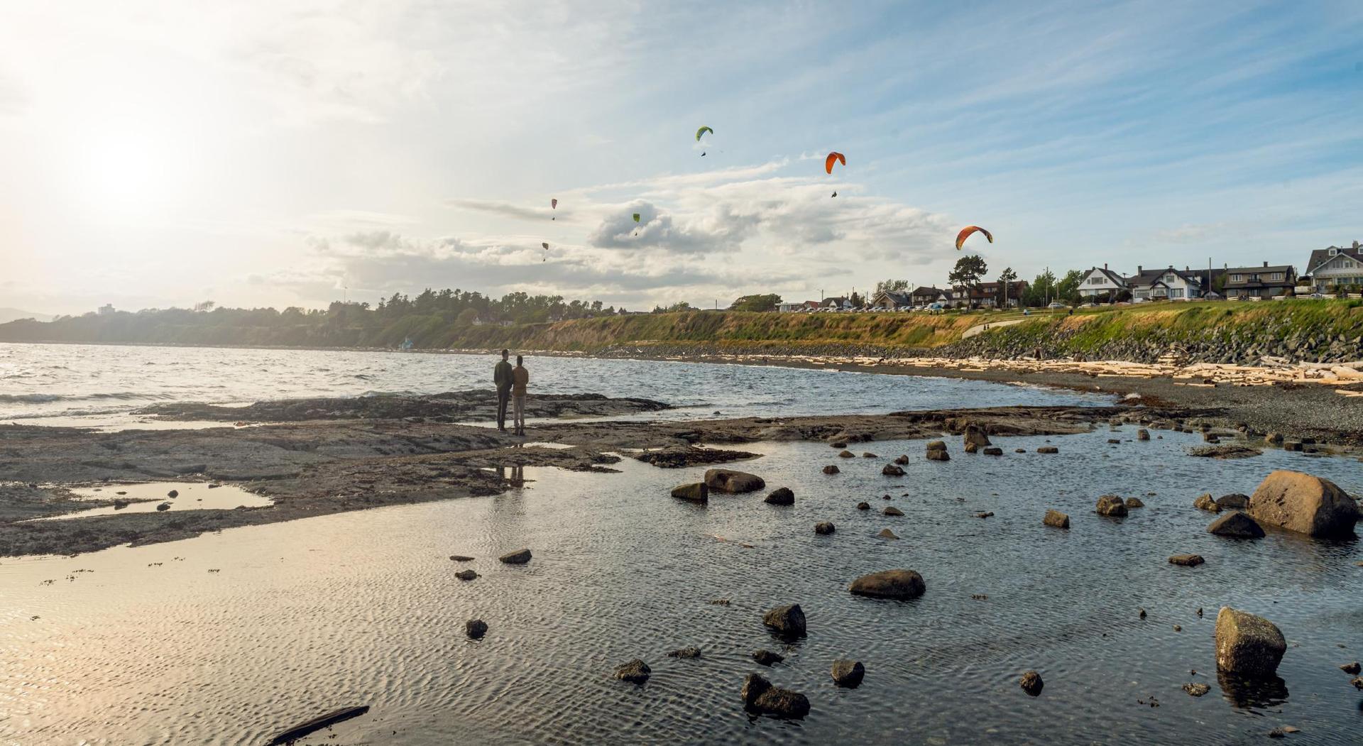 A couple explores the coastline along Dallas Road in Victoria, BC