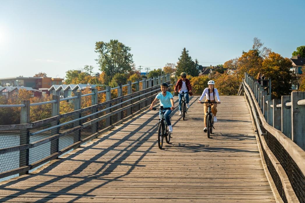 A group of friends ride bikes across the Selkirk Trestle in Victoria, BC