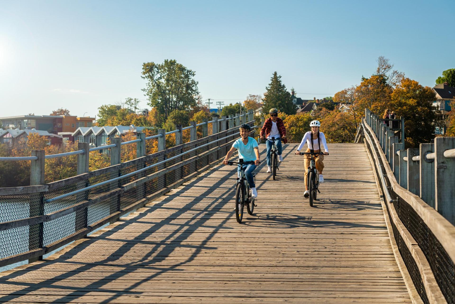 A group of friends ride bikes across the Selkirk Trestle in Victoria, BC